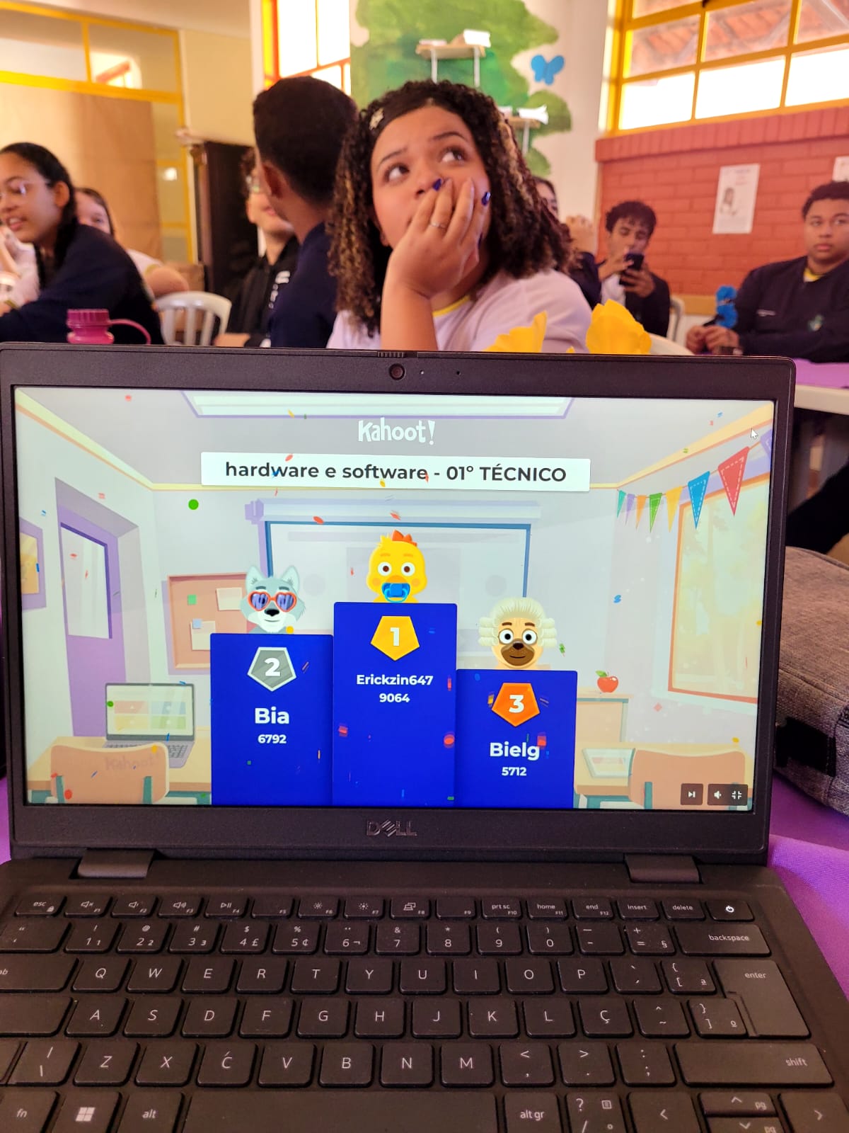 Estudante reagindo ao resultado de um quiz Kahoot sobre hardware e software durante a aula